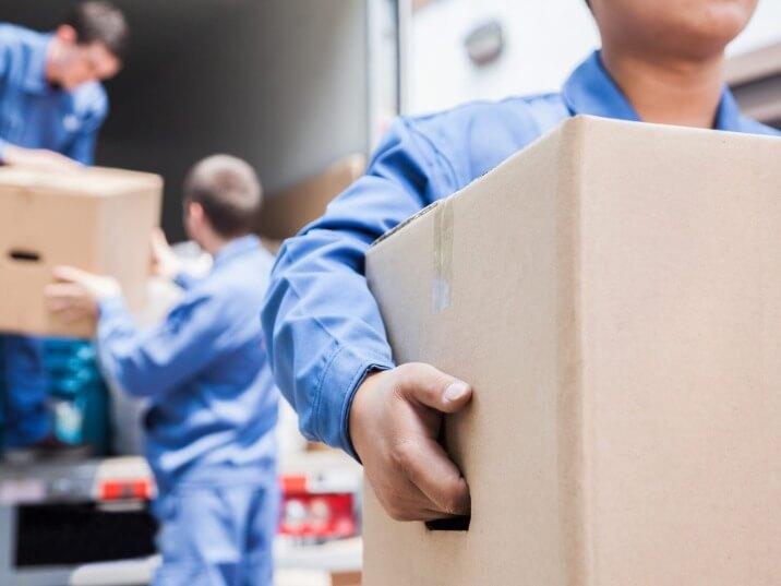 movers carrying a sofa up a flight of stairs
